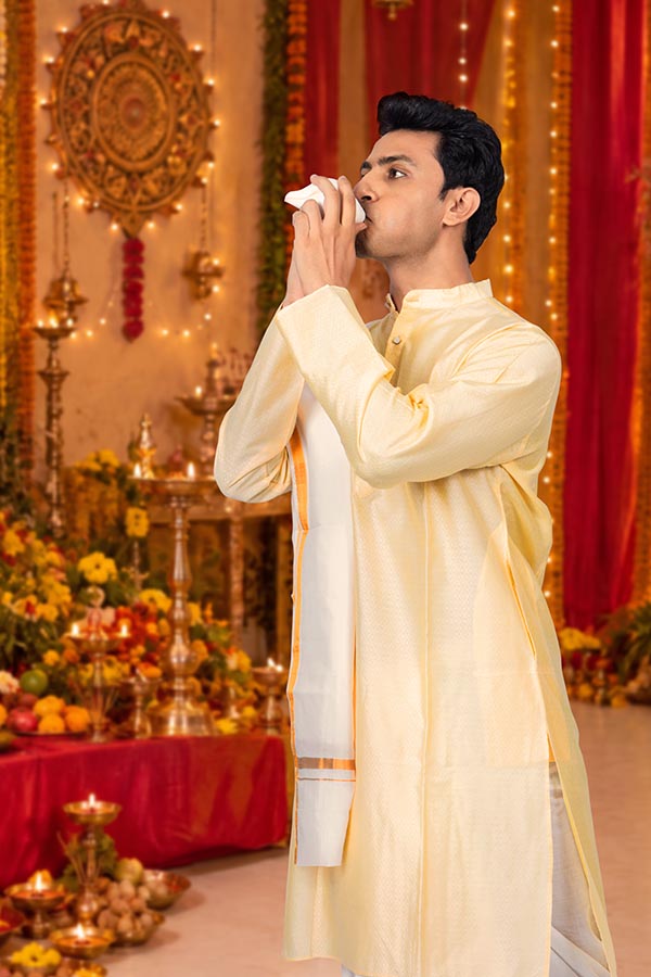 Indian man blowing conch shell during Durga Puja religious celebration