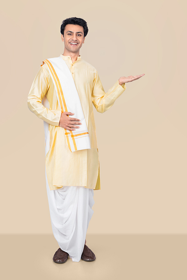 Smiling Indian man presenting with open hand in traditional Durga Puja attire