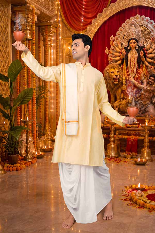 Indian man performing Durga Puja ritual before Goddess Durga idol