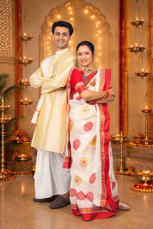 Indian couple posing together in traditional attire during Durga Puja celebration