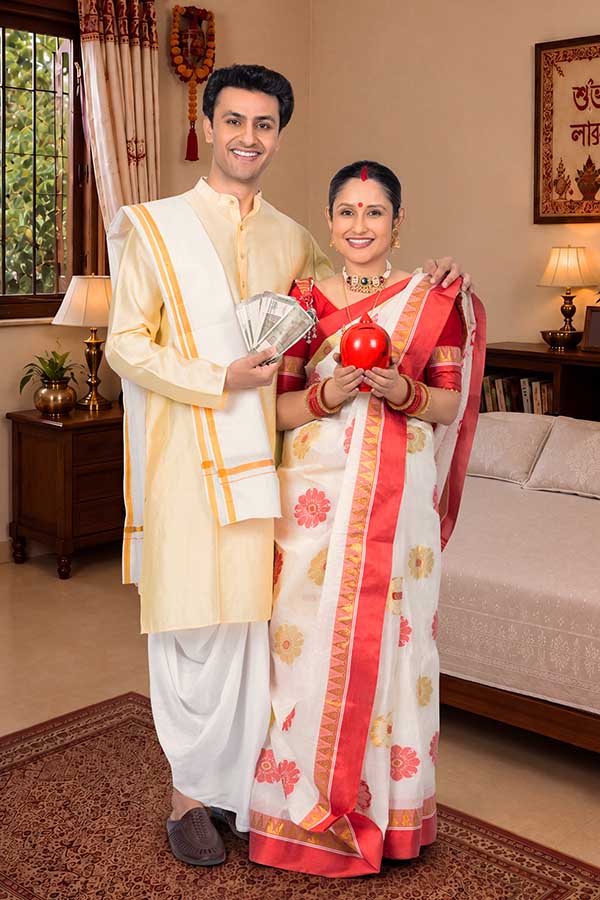 Indian couple celebrating Durga Puja with money and savings concept