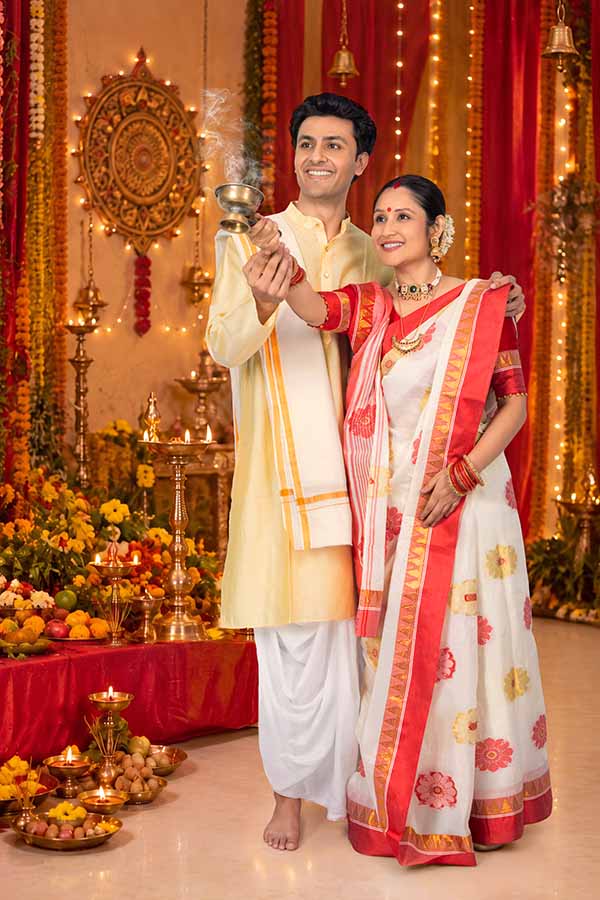 Indian couple performing Durga Puja ritual with incense burner