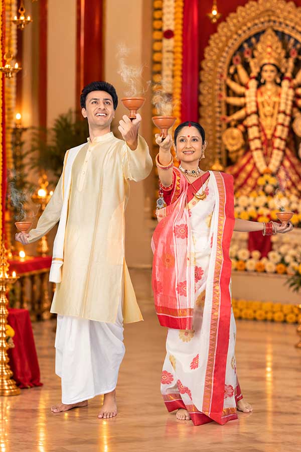 Indian couple performing Dhunuchi ritual during Durga Puja celebration