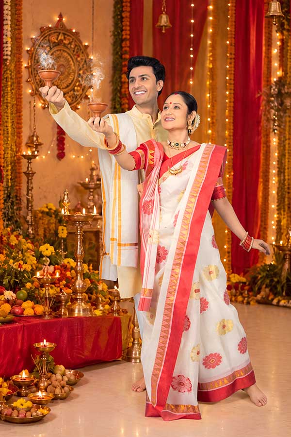 Indian couple performing traditional Dhunuchi worship during Durga Puja