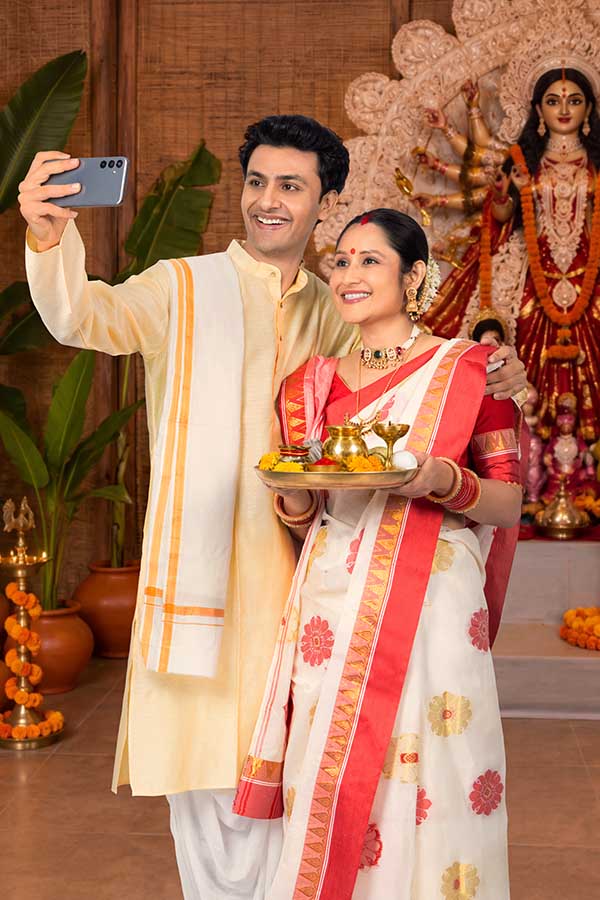 Indian couple taking selfie during Durga Puja celebration