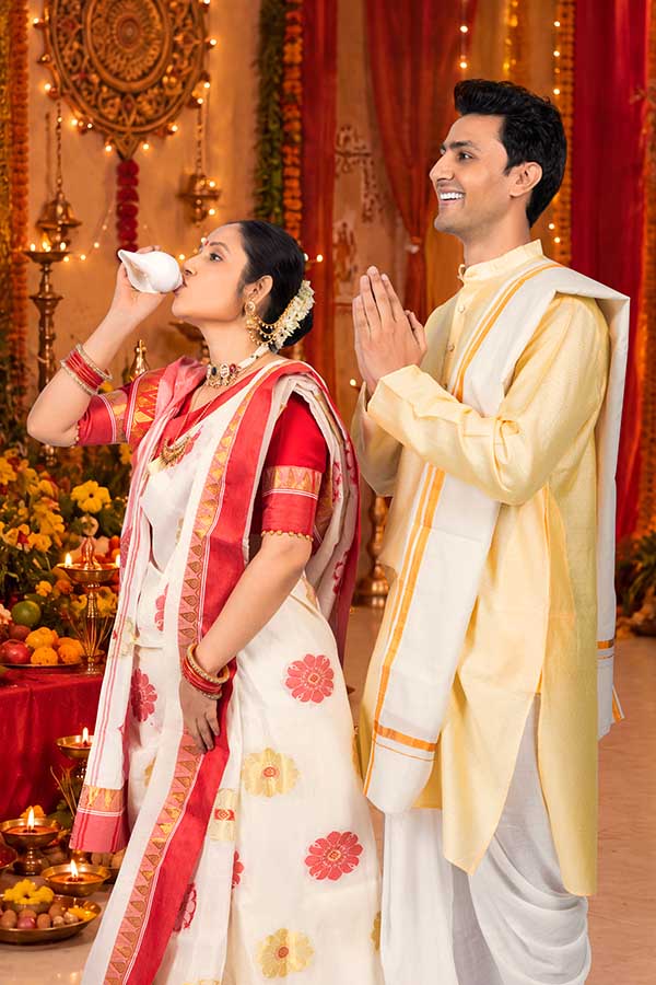 Indian couple praying during traditional Durga Puja conch ritual