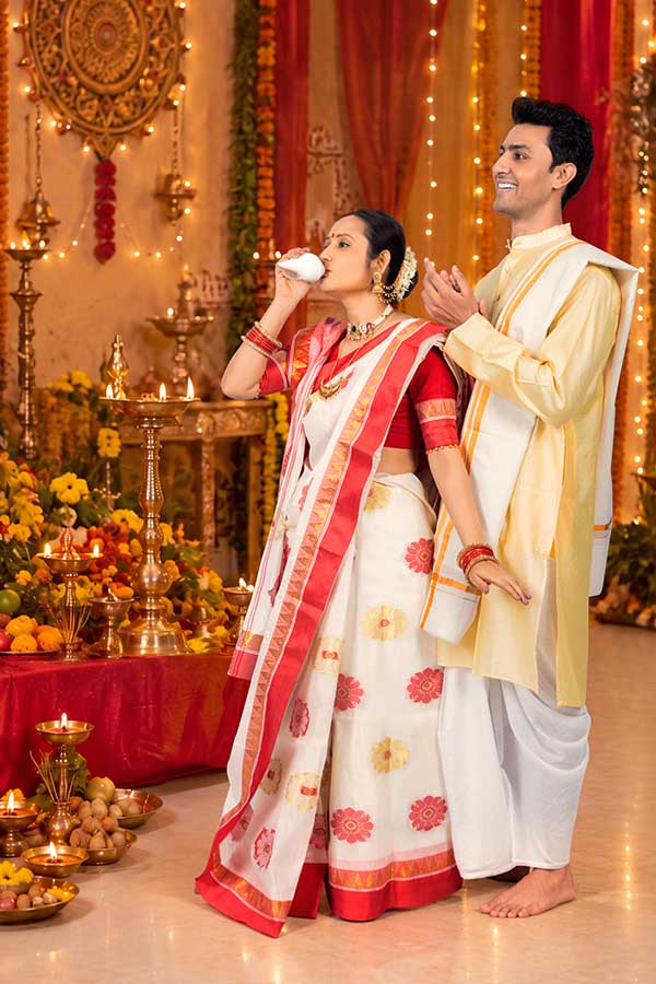 Indian couple performing devotional conch ritual at Durga Puja pandal