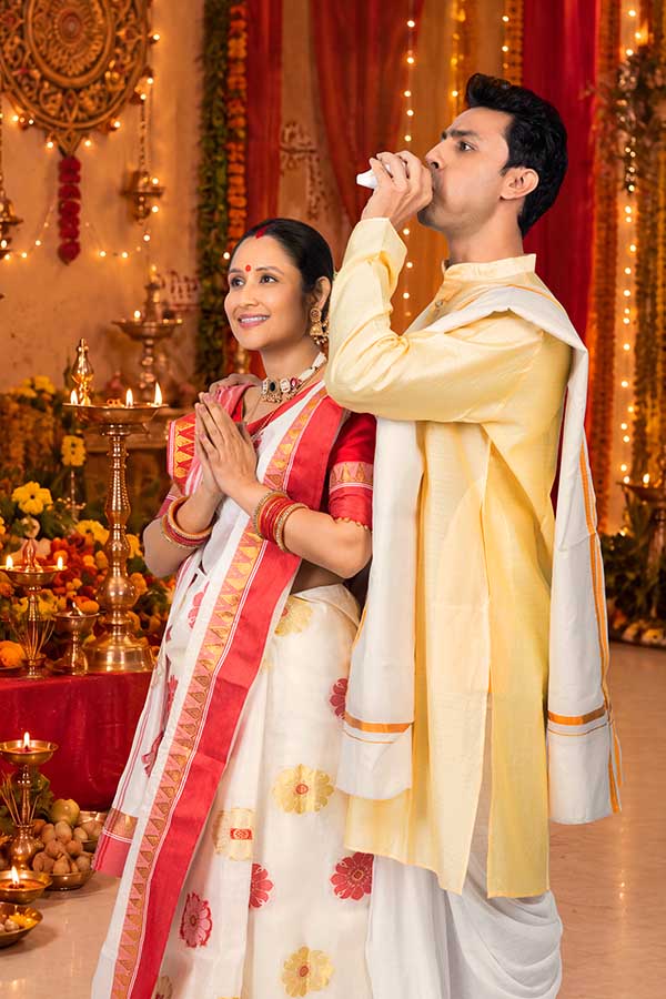 Indian couple performing conch shell worship during Durga Puja