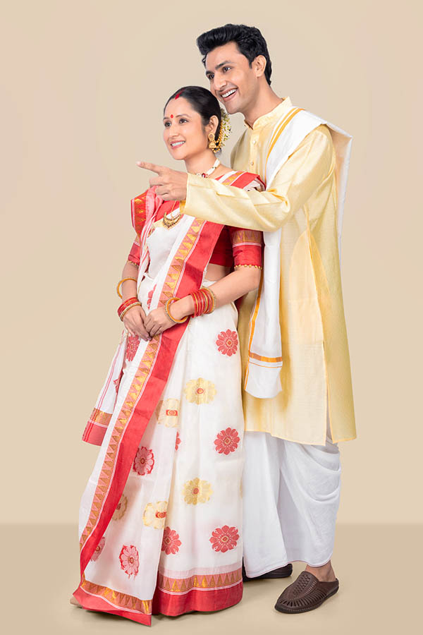 Indian couple celebrating Durga Puja in traditional Bengali attire