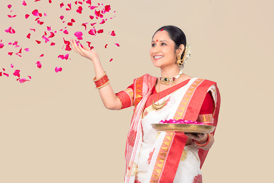 Bengali woman offering flower petals during Indian festival celebration