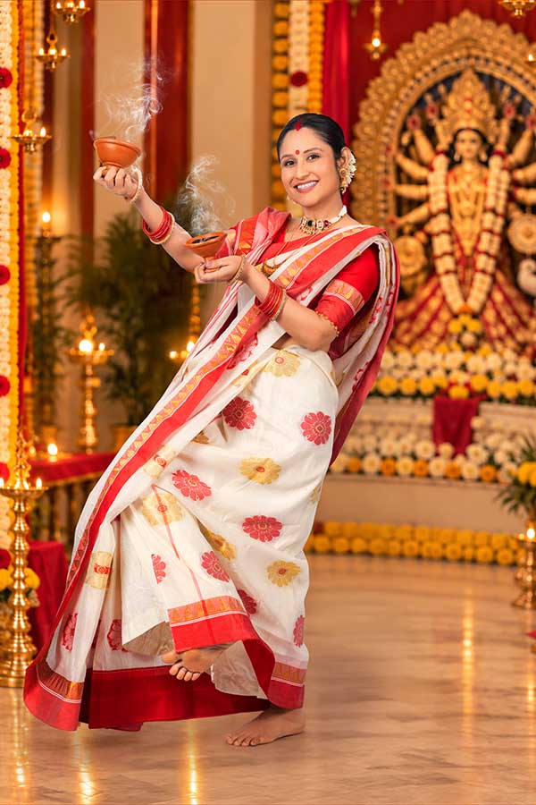 Bengali woman performing traditional dhunuchi worship during Durga Puja