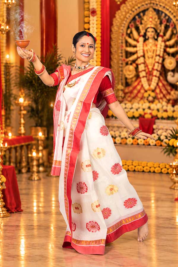Bengali woman performing dhunuchi ritual before Durga idol