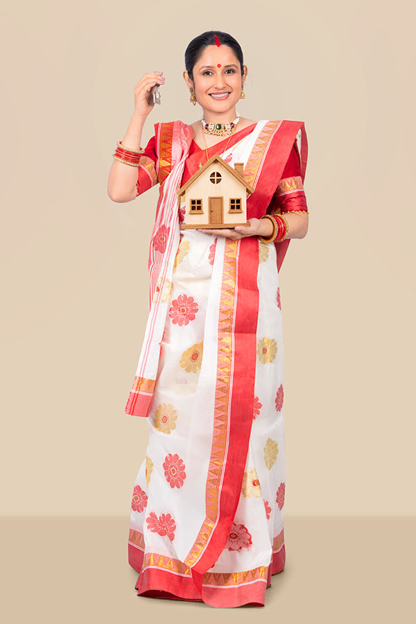 Indian woman holding house model and keys for home ownership concept