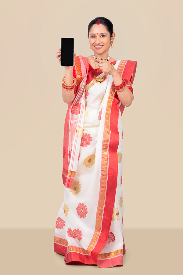 Indian woman holding smartphone for digital technology concept during Durga Puja