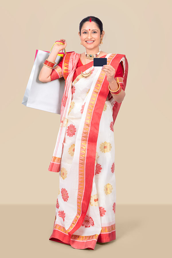 Indian woman holding shopping bags and payment card during festive shopping