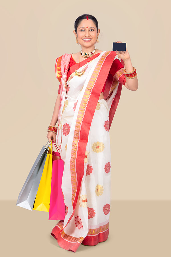 Indian woman holding shopping bags and payment card for festive retail concept