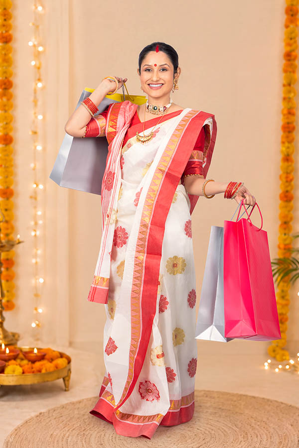 Bengali woman carrying shopping bags during festive celebration