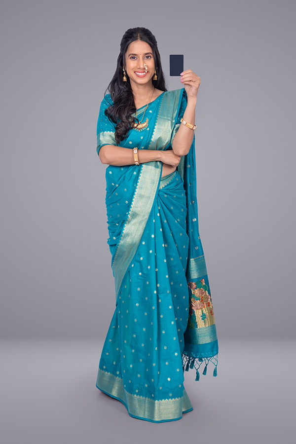 Indian woman holding bank card on studio background