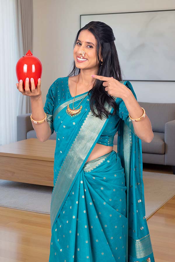 Indian woman pointing at red piggy bank for savings concept