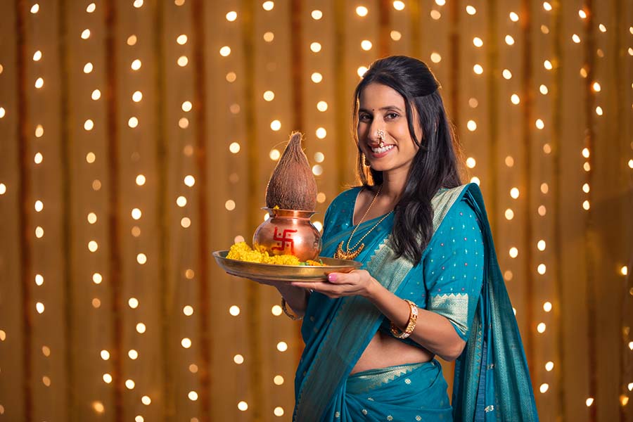 Indian woman holding puja thali before Ganesh festival decoration