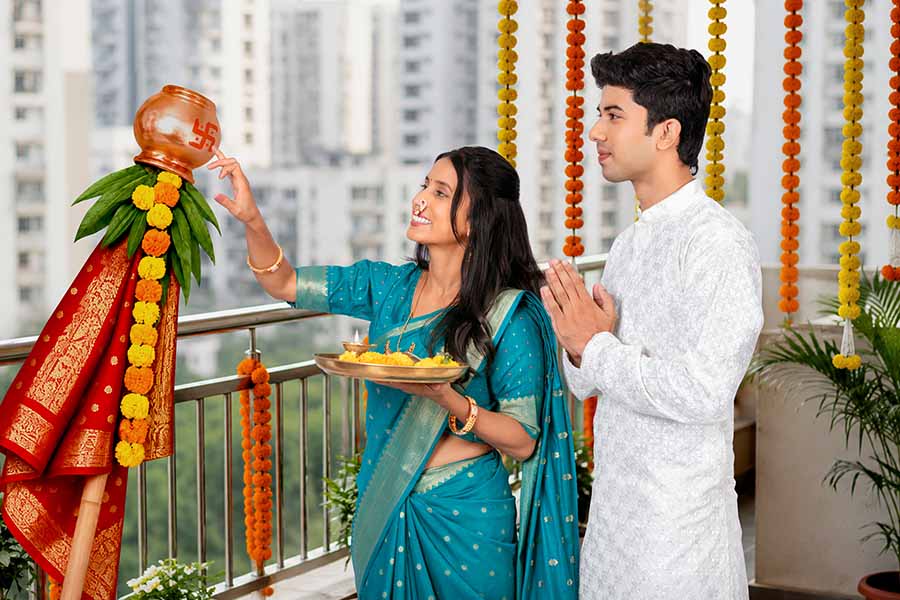 Indian couple performing Gudi Padwa ritual on decorated balcony