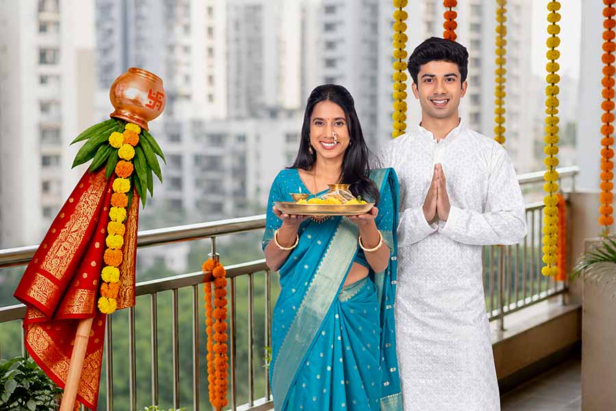 Indian couple celebrating Gudi Padwa with puja thali and namaste