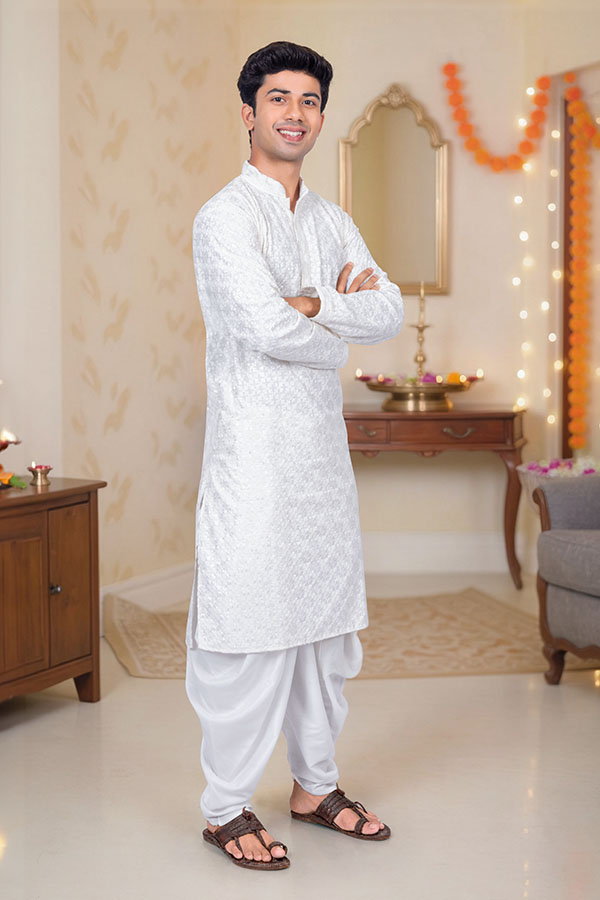 Confident Indian man in traditional kurta posing at festive home