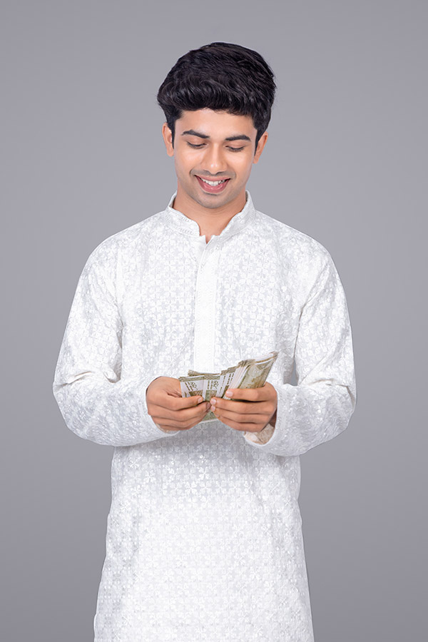 Young Indian man counting money in traditional attire