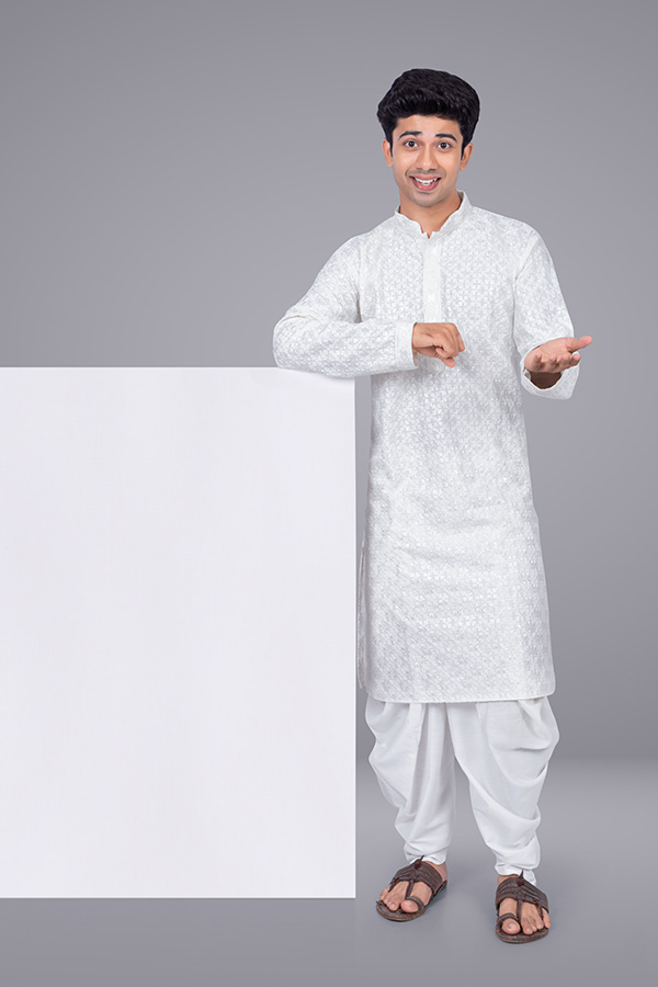 Indian man presenting product over blank display panel in studio