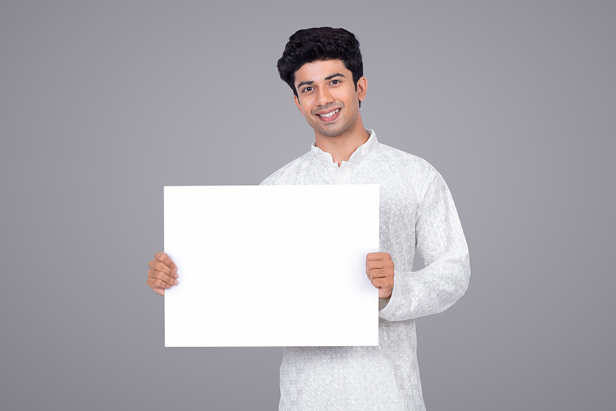 Young Indian man holding blank placard for promotional message