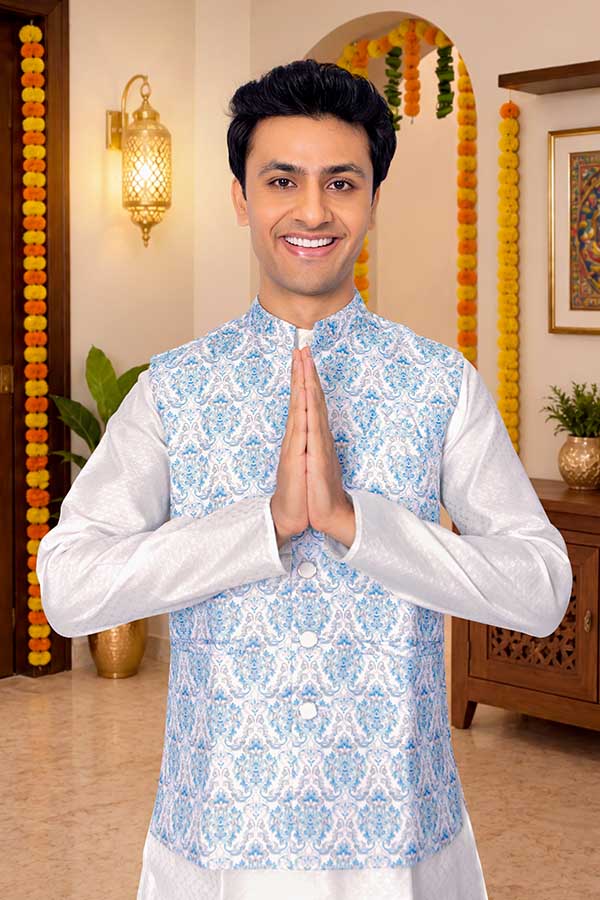 Young Indian man greeting with namaste in decorated festive home