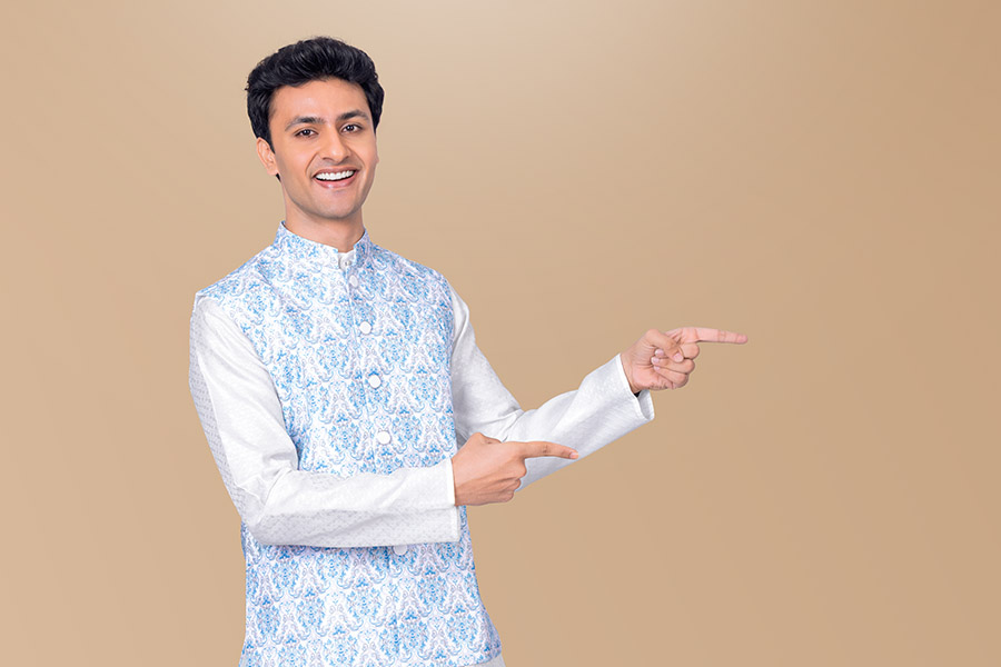 Smiling Indian man pointing towards festive promotional space