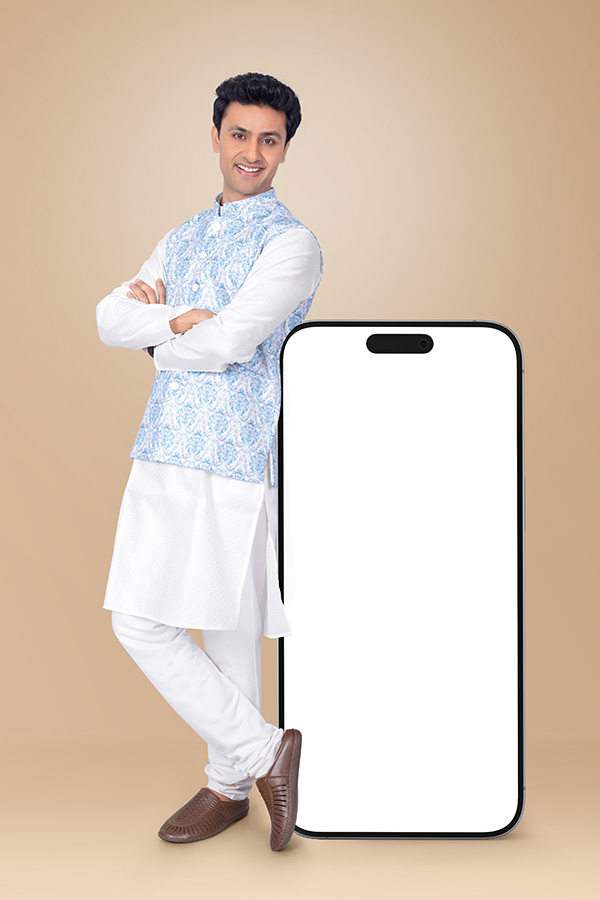 Indian man standing beside oversized smartphone mockup in festive ethnic wear