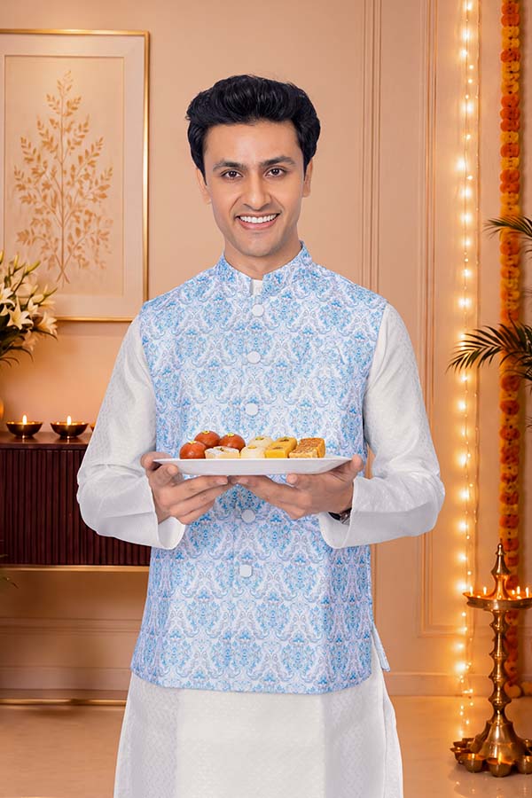 Indian man presenting festive sweets during Diwali celebration