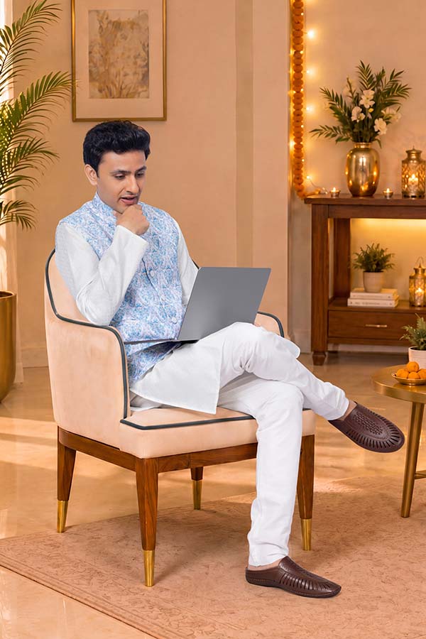 Young Indian man working on laptop in traditional attire during Diwali