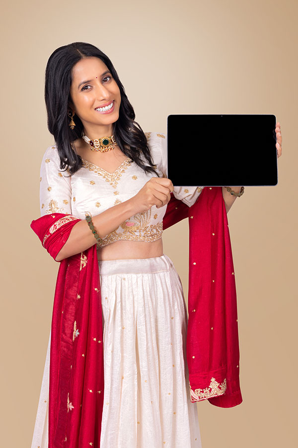 Indian woman displaying tablet with blank screen in festive attire