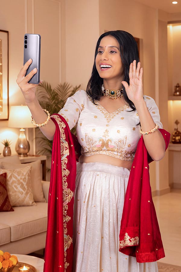 Indian woman waving during festive video call on smartphone