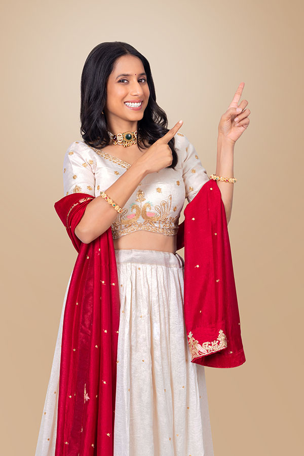 Indian woman pointing to upper corner with both hands