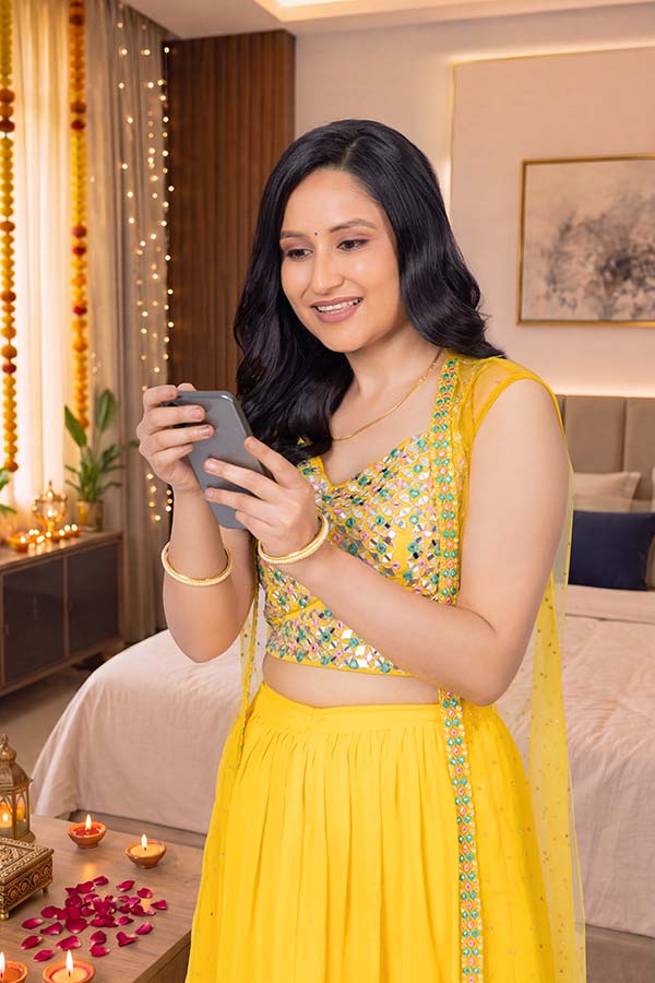 Indian woman enjoying festive mobile shopping from home