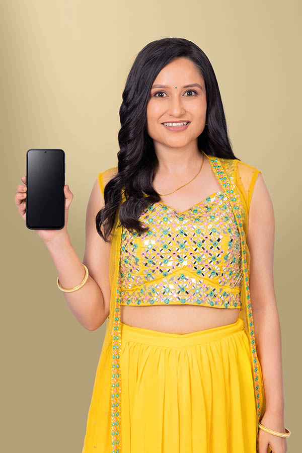 Indian woman displaying blank smartphone screen in festive ethnic attire