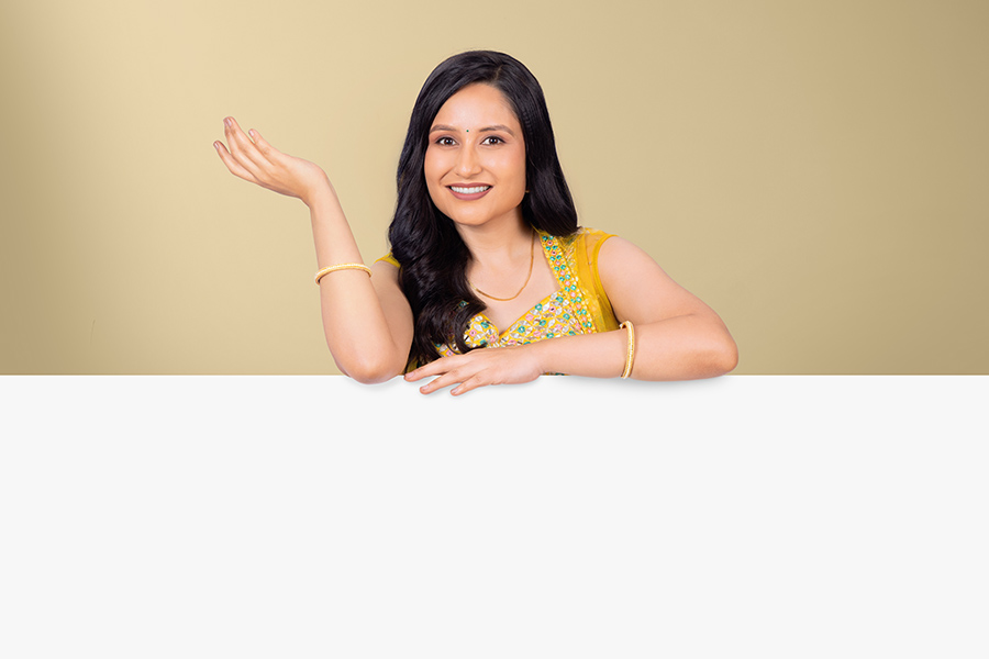 Smiling Indian woman presenting empty copy space over white tabletop for festive promotions