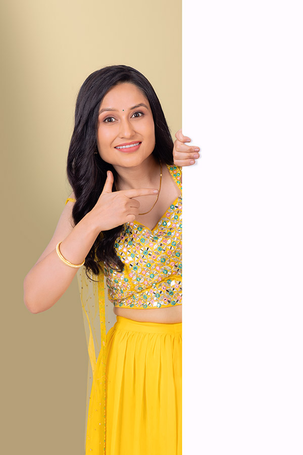 Indian woman pointing at blank vertical banner for festive advertisement