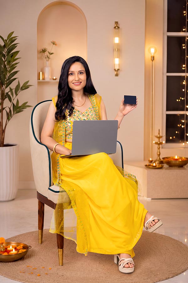 Indian woman using laptop and holding bank card during Diwali online shopping
