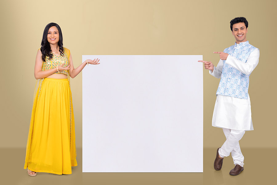 Indian couple presenting blank signboard for Festive promotional campaign