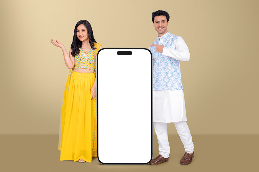 Indian couple presenting blank smartphone mockup for mobile app promotion