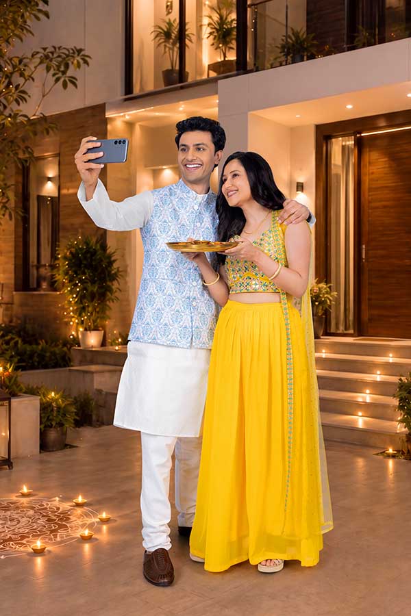 Indian couple taking Diwali selfie with festive puja thali at home