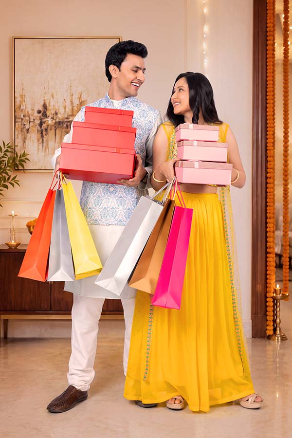 Indian couple carrying shopping bags and gift boxes after festive shopping
