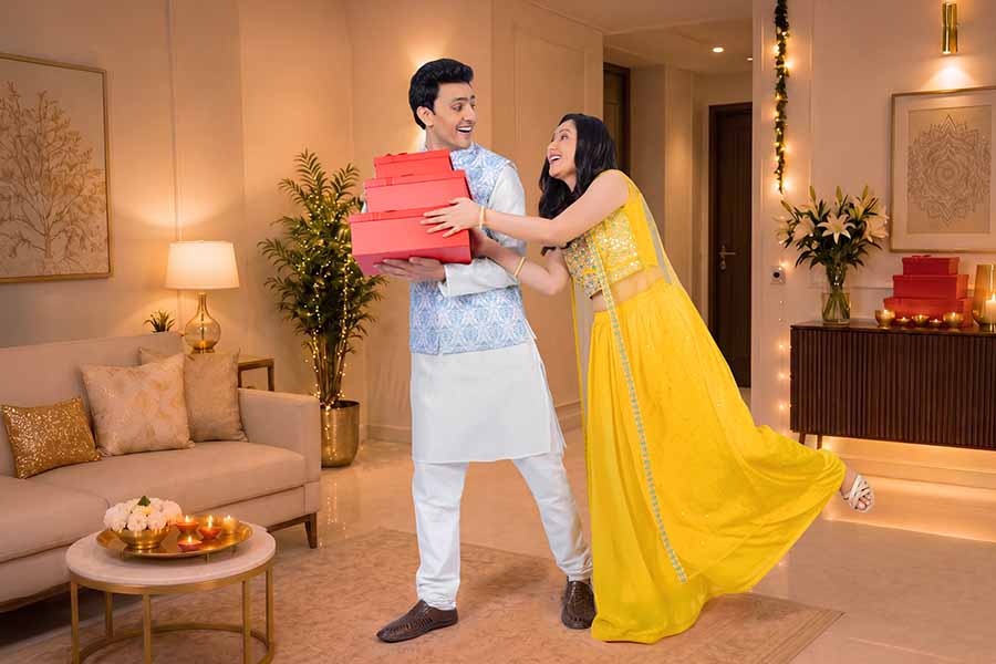 Indian couple exchanging gifts during Diwali celebration at home