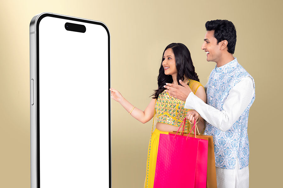 Indian couple shopping online with smartphone during festive season