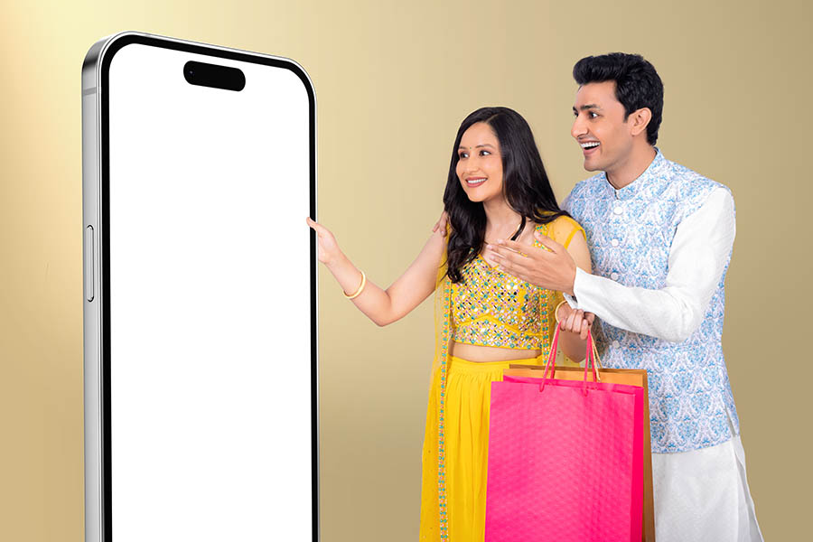 Indian couple enjoying festive online shopping with smartphone display